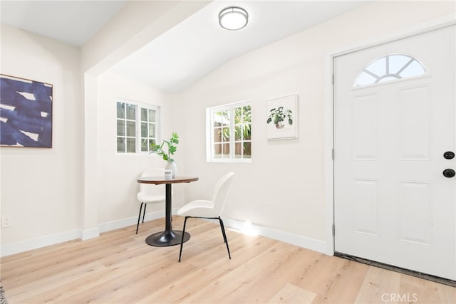 entrance foyer featuring vaulted ceiling, wood finished floors, and baseboards