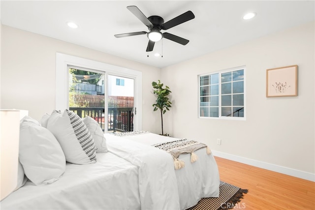 bedroom with baseboards, recessed lighting, wood finished floors, and access to exterior