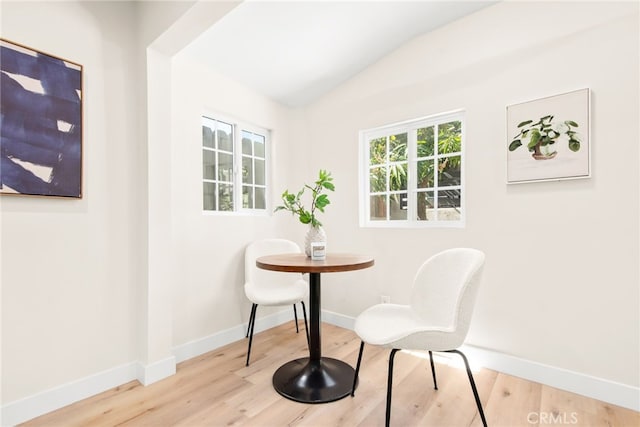 dining area with baseboards, vaulted ceiling, and wood finished floors