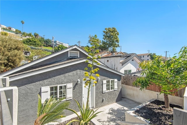 view of side of property with fence and stucco siding