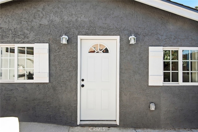 view of exterior entry with stucco siding