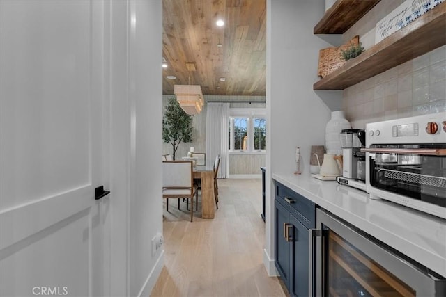 kitchen featuring beverage cooler, open shelves, blue cabinetry, light countertops, and wooden ceiling