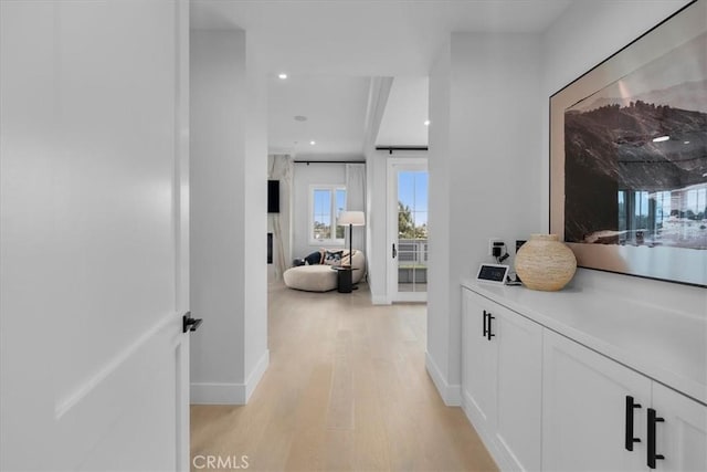 corridor featuring light wood finished floors, recessed lighting, and baseboards