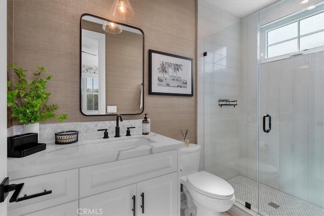 full bath featuring a stall shower, toilet, and vanity