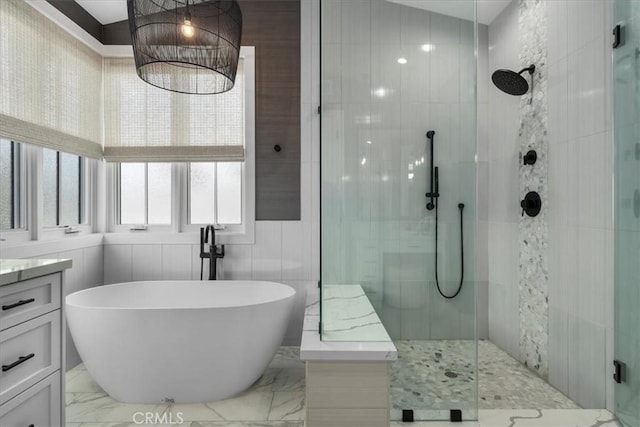 full bathroom featuring vanity, a freestanding tub, marble finish floor, and a tile shower