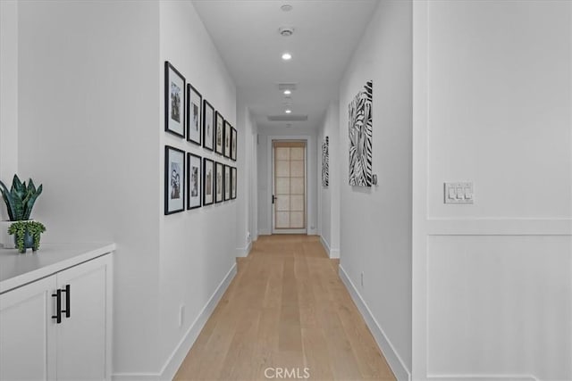 corridor with light wood-style flooring, recessed lighting, and baseboards