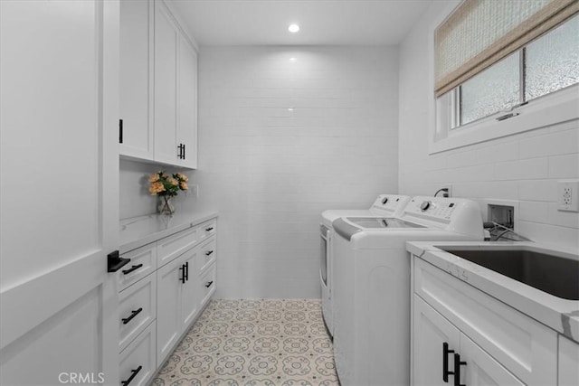 laundry room with a sink, recessed lighting, cabinet space, light tile patterned flooring, and washing machine and clothes dryer