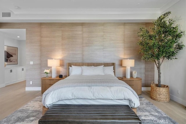 bedroom with light wood-style floors, visible vents, and baseboards