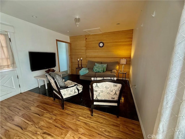 bedroom featuring wood walls, baseboards, and wood finished floors