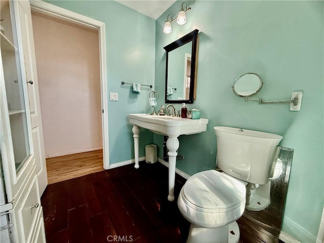 bathroom featuring toilet, baseboards, and wood finished floors