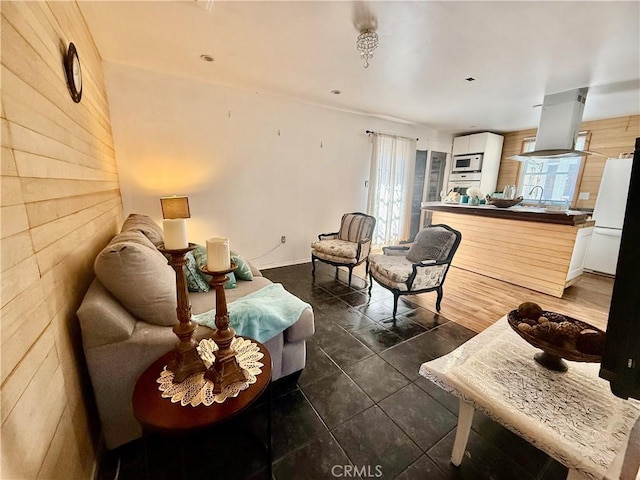 living area featuring wood walls and dark tile patterned flooring