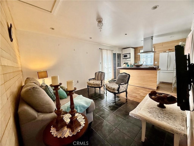 living area with wood walls and dark tile patterned floors