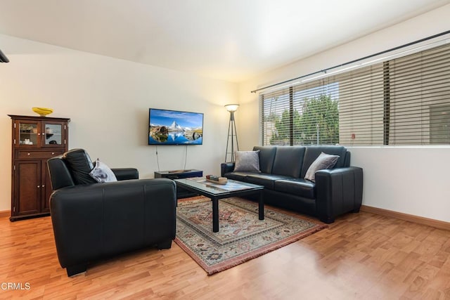 living area with light wood-type flooring and baseboards