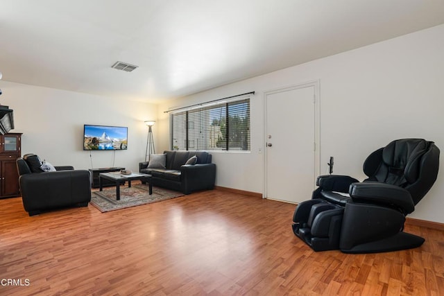 living area featuring visible vents, baseboards, and light wood finished floors