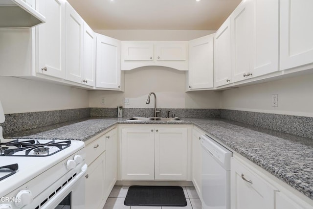 kitchen with light stone countertops, light tile patterned flooring, white appliances, white cabinetry, and a sink