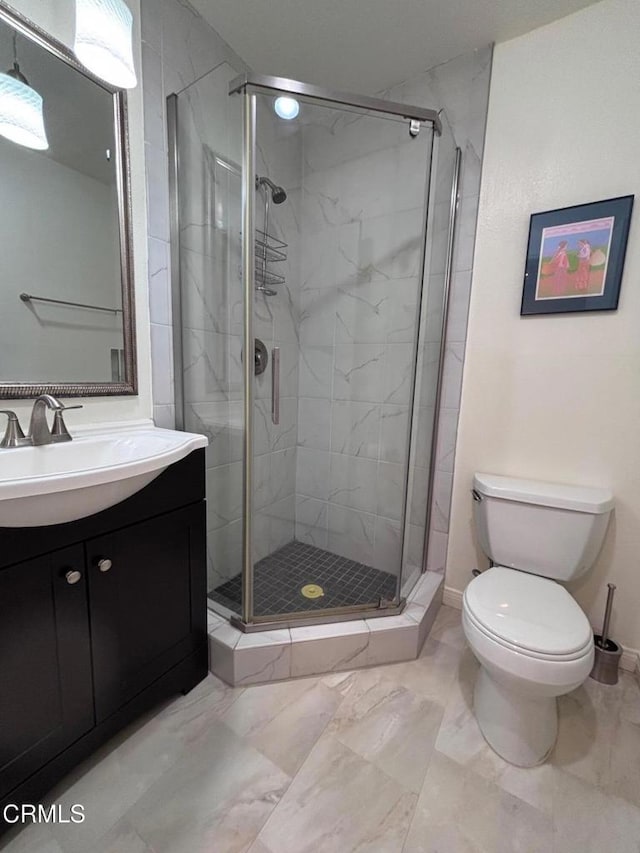 full bathroom featuring vanity, toilet, a stall shower, and marble finish floor