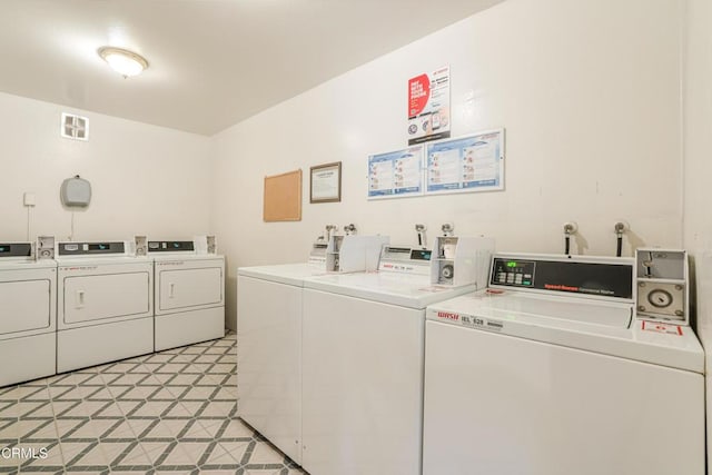 community laundry room featuring light floors and washer and clothes dryer