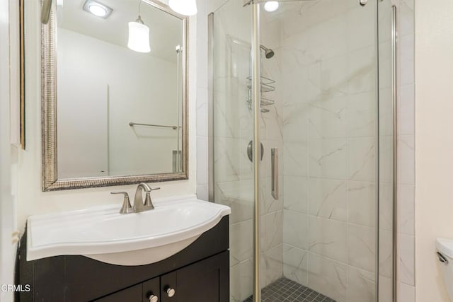 full bathroom featuring a stall shower, toilet, and vanity