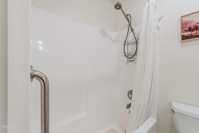 bathroom featuring shower / bath combination with curtain and toilet