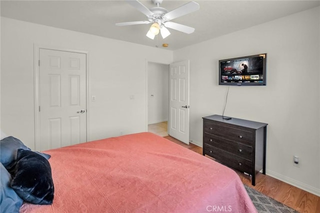 bedroom with ceiling fan, baseboards, and wood finished floors