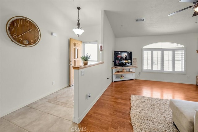 interior space featuring a ceiling fan, a wealth of natural light, visible vents, and light wood-style floors