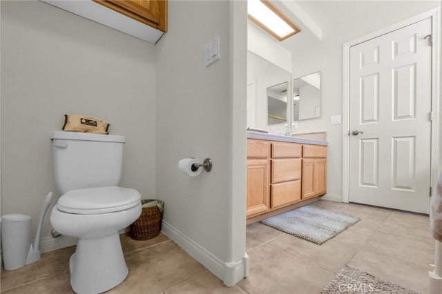 bathroom featuring toilet, tile patterned flooring, baseboards, and vanity