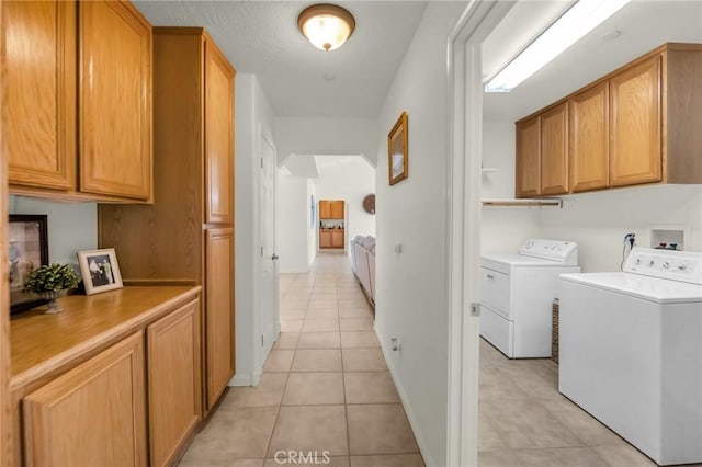 laundry room with cabinet space, washing machine and clothes dryer, and light tile patterned floors