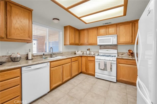 kitchen featuring white appliances, visible vents, light countertops, and a sink