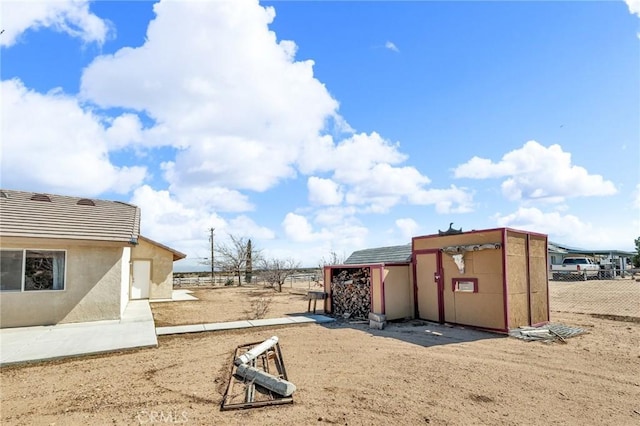 view of yard with a shed, fence, and an outdoor structure