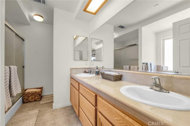 full bathroom featuring visible vents, a sink, a shower stall, and tile patterned floors