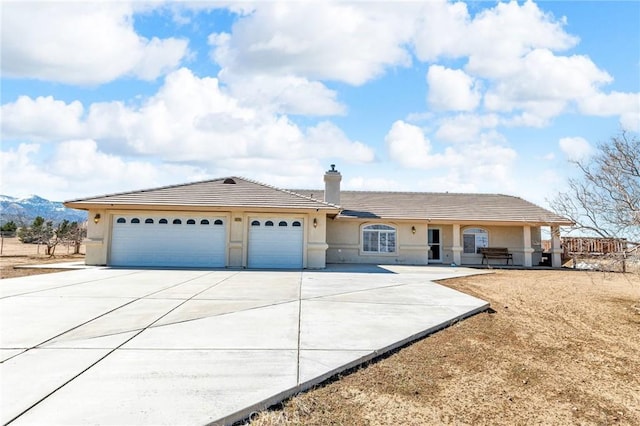 ranch-style house with a garage, a tile roof, driveway, stucco siding, and a chimney