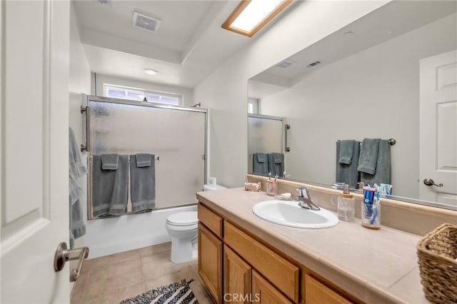 full bathroom with visible vents, toilet, shower / bath combination with glass door, tile patterned floors, and vanity