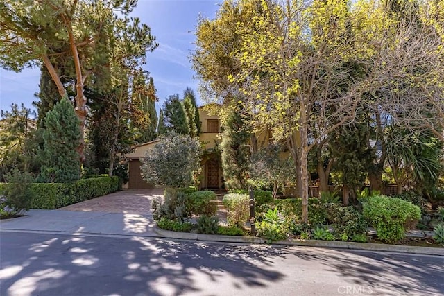 view of front facade featuring driveway, a garage, and stucco siding