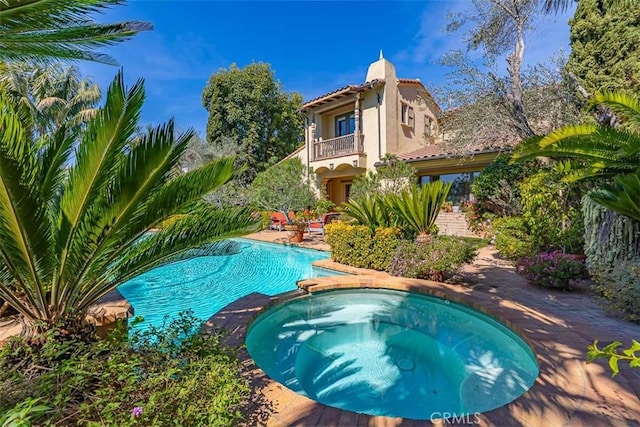 view of swimming pool featuring a pool with connected hot tub and a patio area