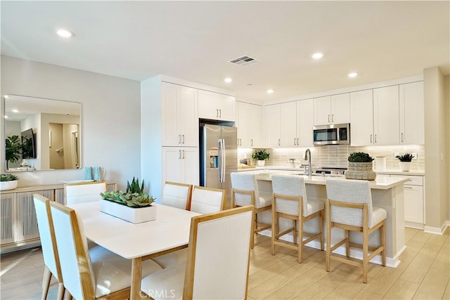 dining area featuring light wood-style floors, visible vents, and recessed lighting