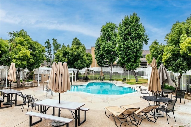 pool with a patio area and fence