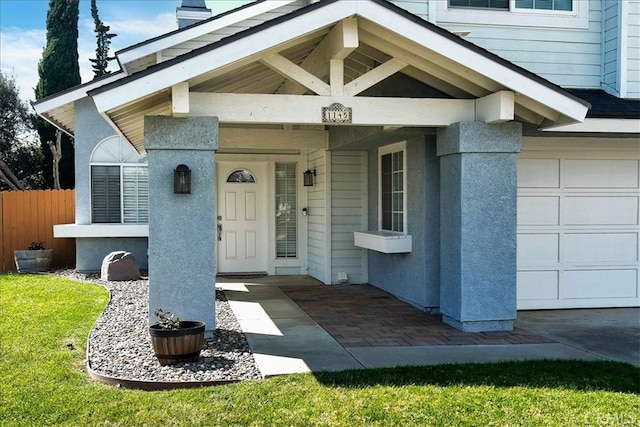 entrance to property with a garage and fence