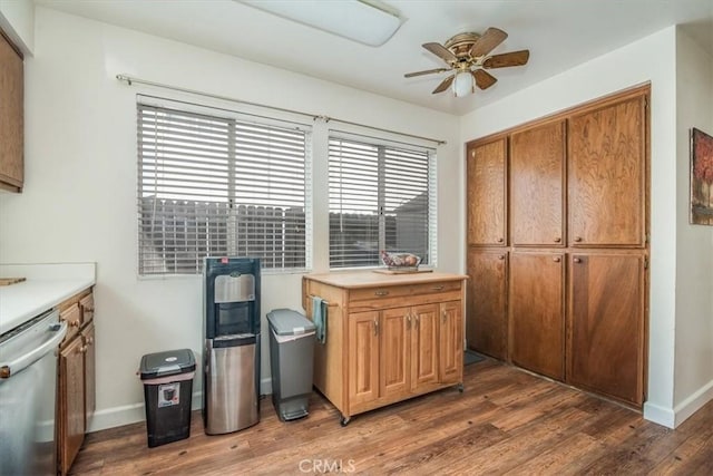 kitchen with ceiling fan, wood finished floors, baseboards, light countertops, and dishwasher