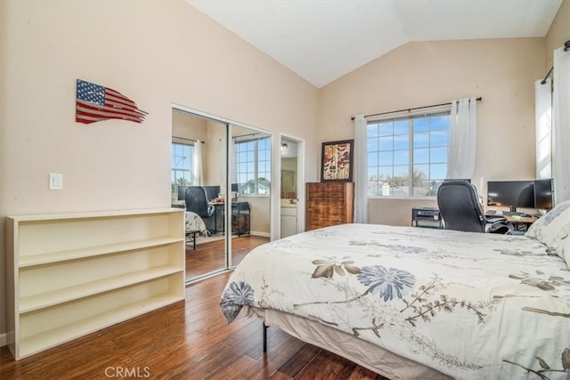 bedroom with a closet, vaulted ceiling, and wood finished floors