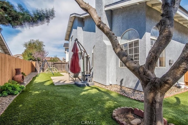 view of property exterior with a patio, a yard, a fenced backyard, and stucco siding