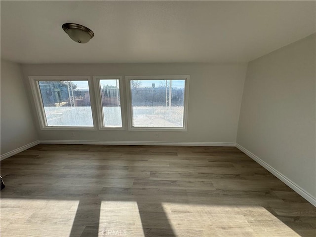 spare room with wood finished floors and baseboards