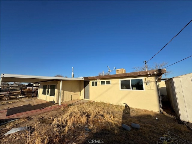 back of property with fence and stucco siding