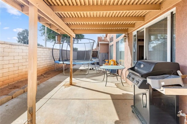 view of patio / terrace with a trampoline, a grill, and a fenced backyard