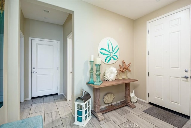 entryway with baseboards and wood tiled floor