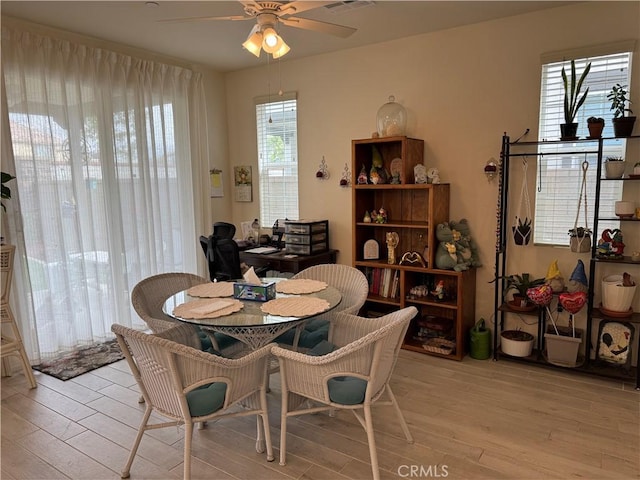 dining area featuring a ceiling fan, visible vents, and light wood finished floors