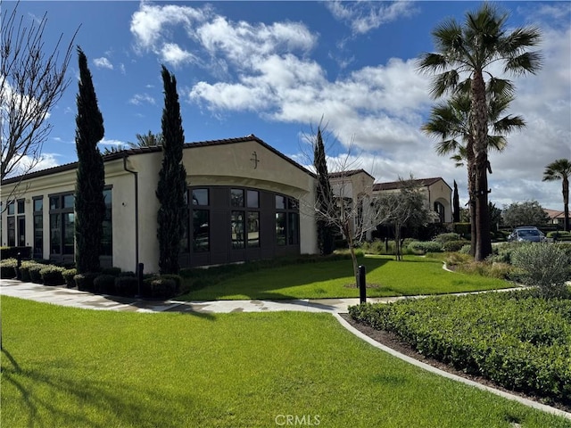 exterior space with stucco siding and a front yard