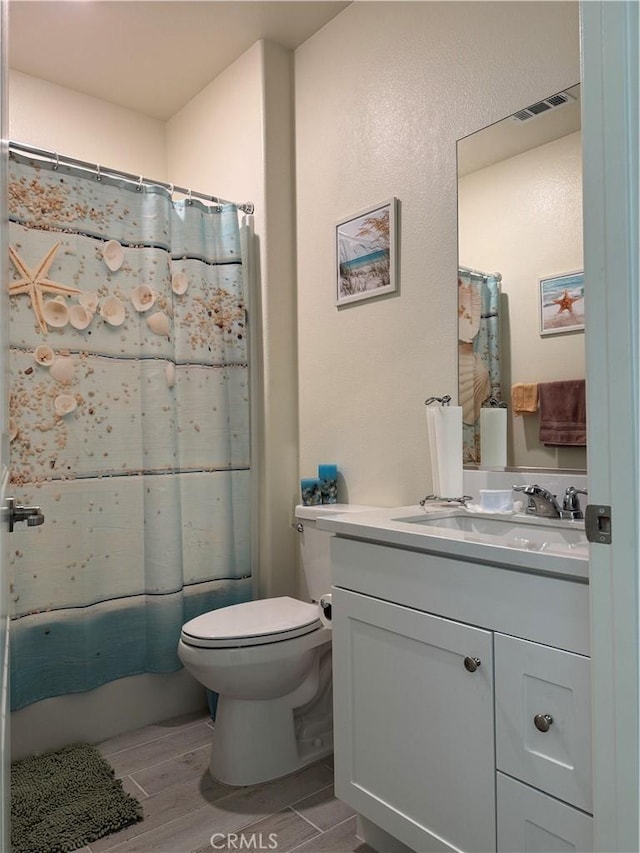 full bathroom with vanity, visible vents, wood finish floors, curtained shower, and toilet