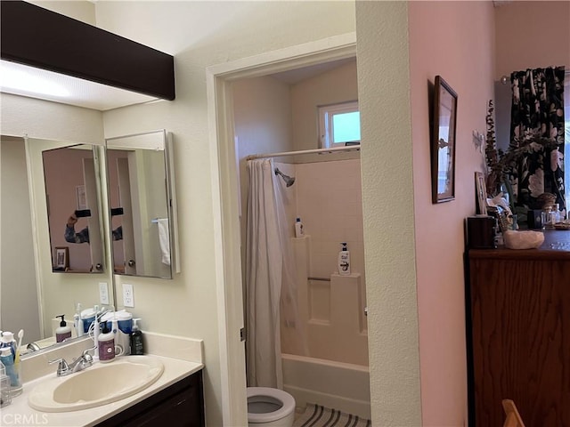 bathroom with vanity, shower / tub combo, and toilet