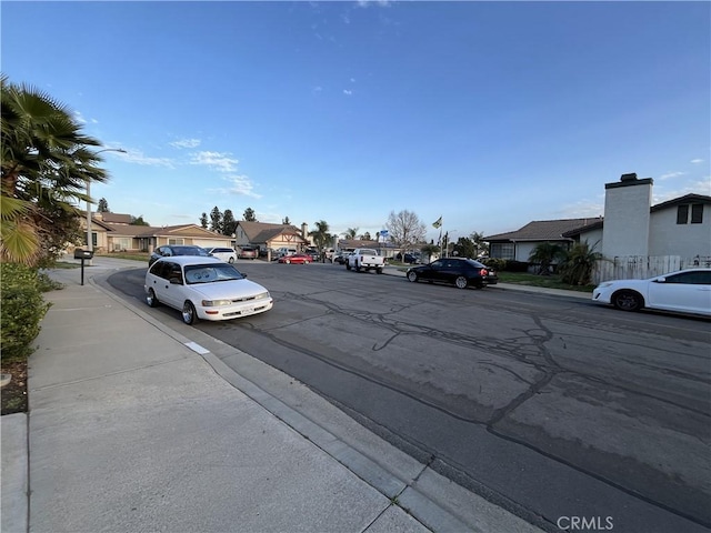 view of road with a residential view, curbs, street lighting, and sidewalks