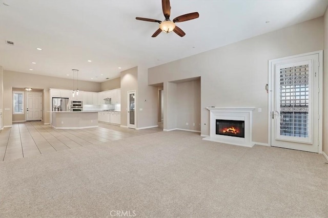 unfurnished living room featuring ceiling fan, recessed lighting, light carpet, visible vents, and a glass covered fireplace